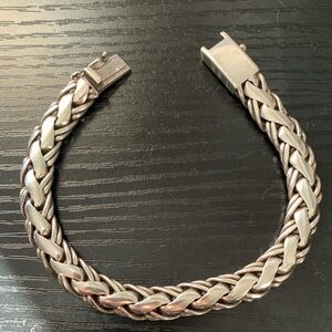 Solid sterling silver bracelet featuring a braided chain design.